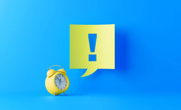 istock Yellow Alarm Clock And Yellow Speech Bubble With Exclamation Point On Blue Background 1143751006