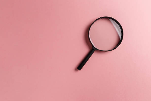 istock Magnifying glass on pink background. Top view. Flat lay. Copy space. Minimal creative concept. Search concept 1143751697