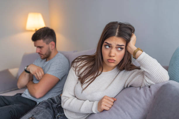 istock A man sitting on a couch is having an argument with his girlfriend who has her head turned away 1143759648
