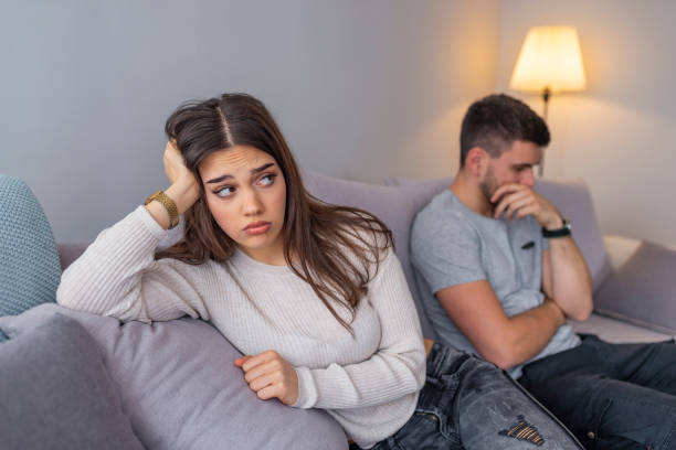 istock A man sitting on a couch is having an argument with his girlfriend who has her head turned away 1143759929