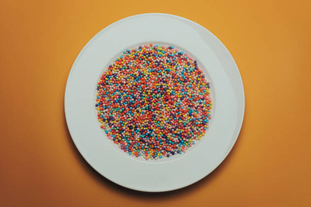 istock White plate with color preparations (vitamins, dyes, flavor enhancers, nutritional supplements, innovative technologies, candy sweets) on an orange background. 1143761986