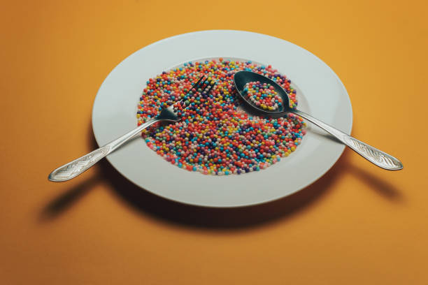 istock White plate with color preparations (vitamins, dyes, flavor enhancers, nutritional supplements, innovative technologies, candy sweets) on an orange background. 1143762074