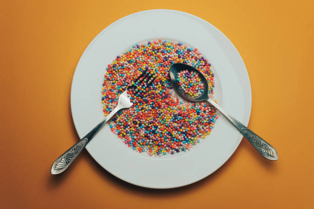 istock White plate with color preparations (vitamins, dyes, flavor enhancers, nutritional supplements, innovative technologies, candy sweets) on an orange background. 1143762086
