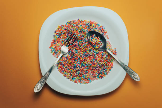 istock White plate with color preparations (vitamins, dyes, flavor enhancers, nutritional supplements, innovative technologies, candy sweets) on an orange background. 1143762395