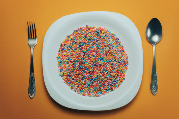 istock White plate with color preparations (vitamins, dyes, flavor enhancers, nutritional supplements, innovative technologies, candy sweets) on an orange background. 1143763064