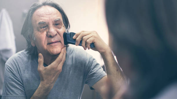 istock Mature man shaving in front of mirror 1143763110