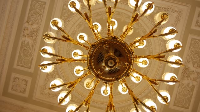 large round gold antique chandelier hanging on the ceiling