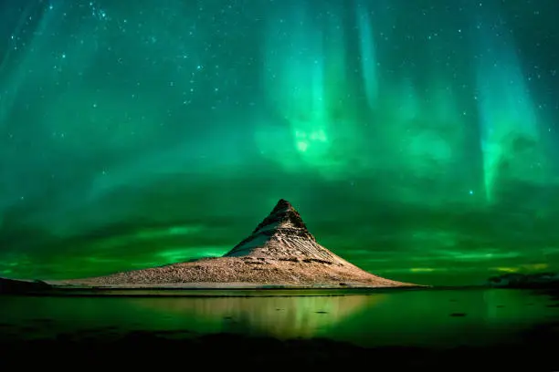 landscape in night time of Kirkjufell mountain and aurora borealis.