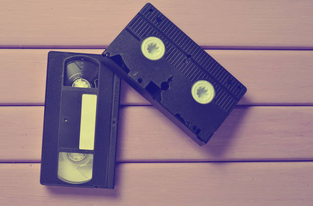 istock Video cassette on a purple wooden table. Retro video technology. Top view. 1143774451