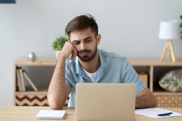 istock Tired student or employee working with laptop, doing boring job 1143775463