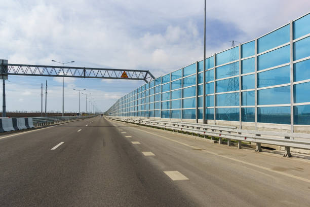 Blue light-transmitting noise-absorbing screens on the new road A290 (formerly M25) near the village of Taman