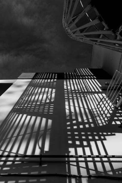 istock Shadow of a spiral staircase cast upon a rendered concrete wall 1143787959
