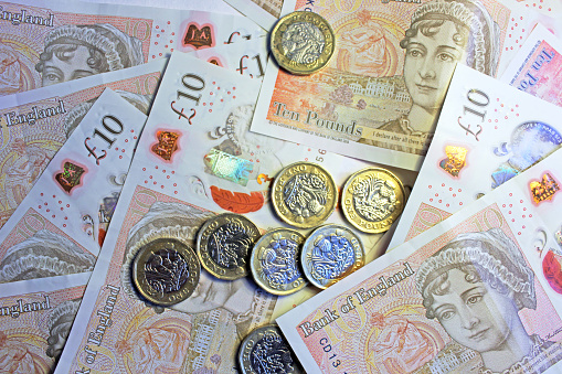 Close-up of pound coins on ten pound notes.