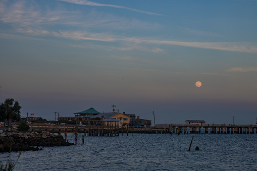 The moon rises over the Dock Street district in historic Cedar Key, Florida