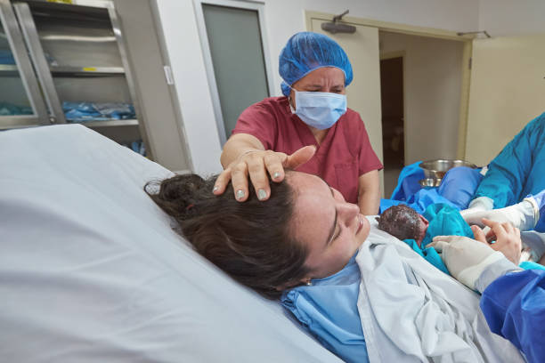 jeune femme retenant le bébé nouveau-né - cesarean photos et images de collection