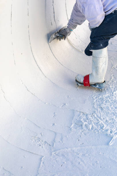 istock Worker Wearing Spiked Shoes Smoothing Wet Pool Plaster With Trowel 1143806950