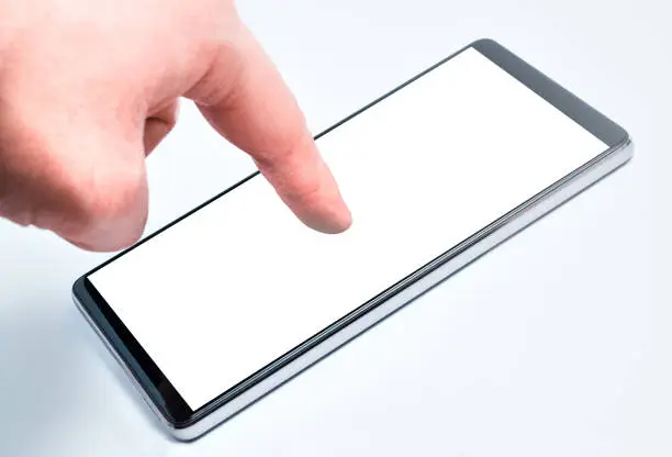A human hand touches the touchscreen of a modern and technological smartphone with the tip of the index finger