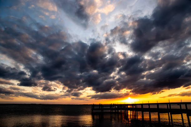 istock People on a wooden pier at sunset. 1143821171
