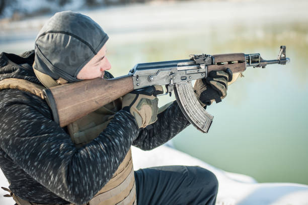 istock Army soldier in crouching position shooting from rifle machine gun 1143822796