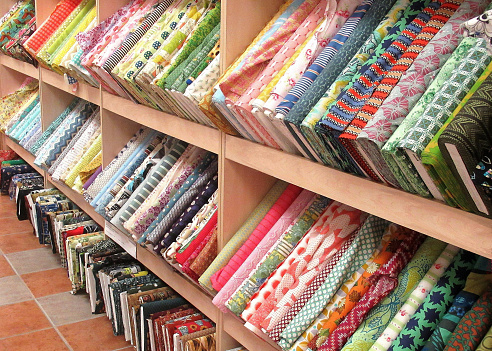 Lifestyle...This image shows several racks with carefully laid out, brightly colored, cloth fabric.