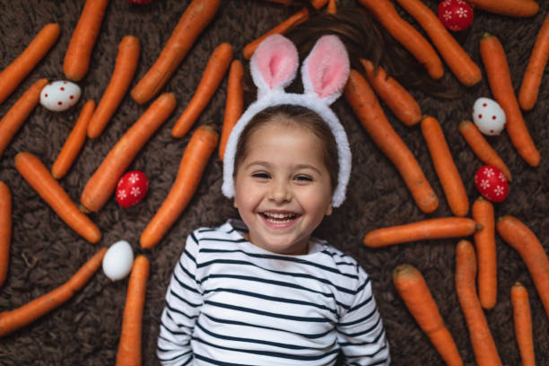 istock Gorgeous cheerful child between carrots and Easter eggs 1143828169