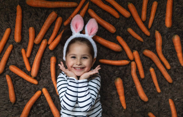 istock Cheerful child lying on a carpet with carrots during Easter 1143830136