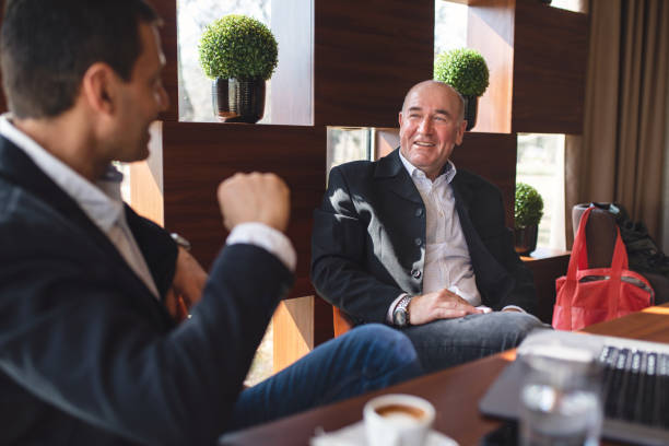 istock Comfortable businessmen enjoying coffee together at a cafe 1143833089