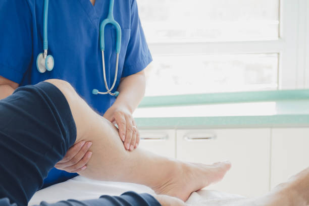 doctor giving a patient a leg treatment - orthopedics imagens e fotografias de stock