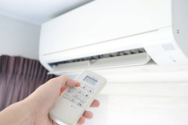 istock Man's hand using remote control open The air conditioner is cooled to 25 degrees Celsius in his bedroom. Health concepts and energy savings 1143847484