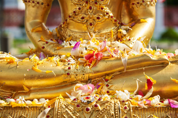 istock Flowers on Buddha statue after pouring water 1143849528
