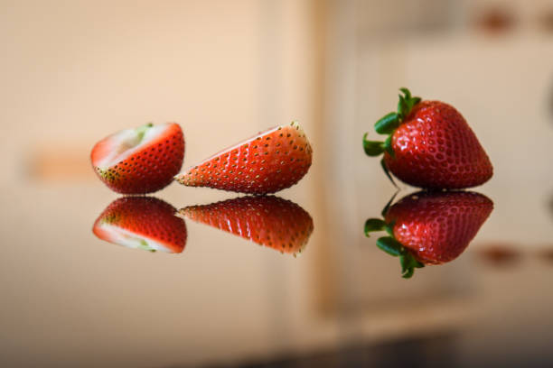 reflexão das morangos na superfície do plexiglás - unhealthy eating flash - fotografias e filmes do acervo