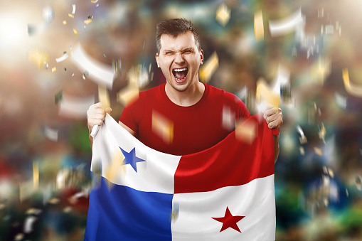 Panamanian fan, fan of a man holding the national flag of Panama in his hands. Soccer fan in the stadium.