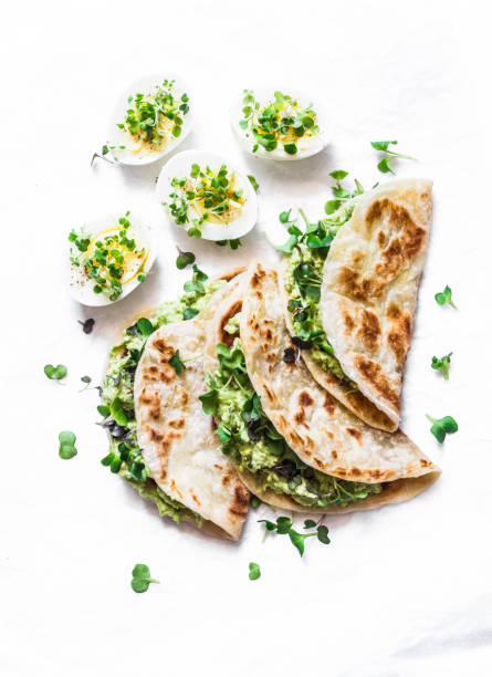 istock Avocado cream cheese micro greens quesadilla and boiled eggs on a light background, top view. Delicious healthy breakfast, snack, brunch. Flat lay 1143859384