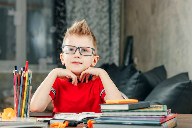 istock Little boy doing homework in school. 1143860130