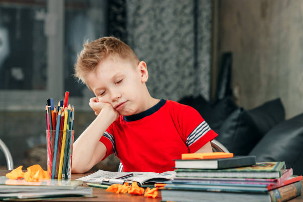 istock The little boy is sad, bored to do homework. 1143860133