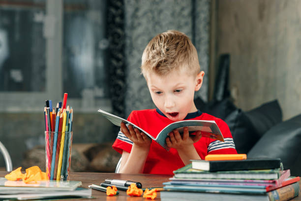 istock Little boy doing homework in school. 1143860146