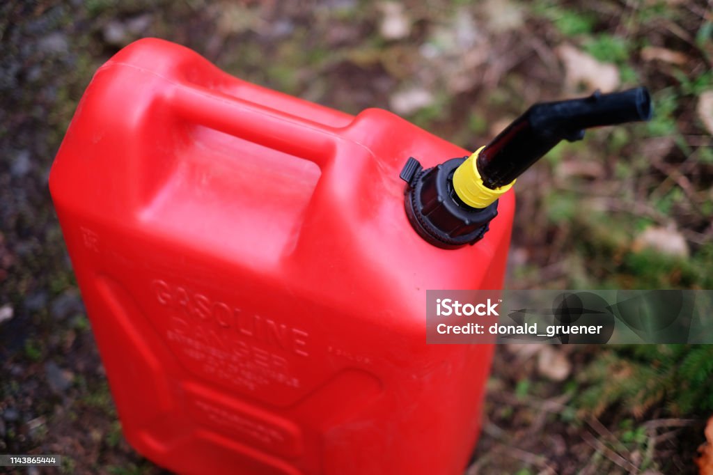 Gas Can on Forest Road A 5-gallon gas can in use along a forest road Gas Can Stock Photo
