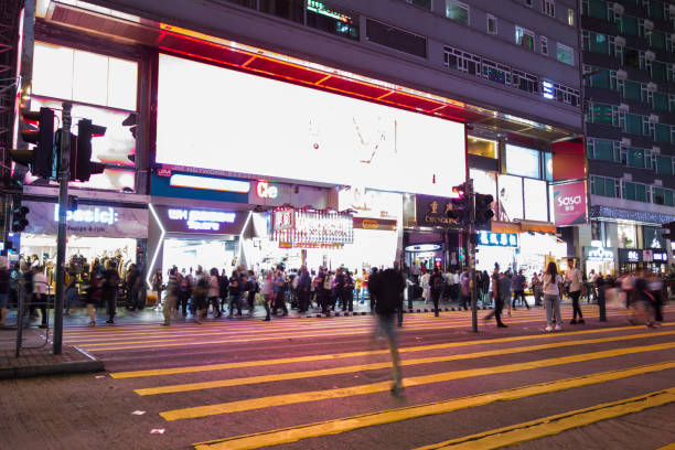 tsim sha tsui, hong kong-07 novembre, 2018: les gens marchent dans le quartier de tsim sha tsui. tsim sha tsui est l’une des principales zones commerçantes de hong kong. - hong shopping night skyline photos et images de collection