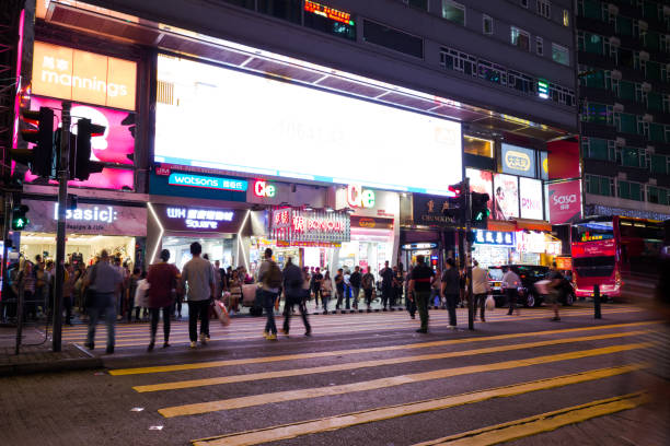 tsim sha tsui, hong kong-07 novembre, 2018: les gens marchent dans le quartier de tsim sha tsui. tsim sha tsui est l’une des principales zones commerçantes de hong kong. - hong shopping night skyline photos et images de collection