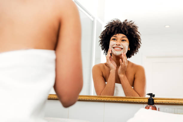 istock Smiling woman applying natural cream on her face 1143867304