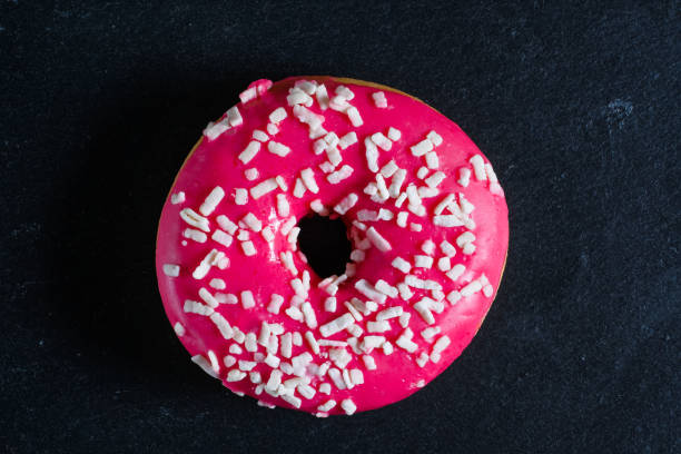 istock Glazed pink donut on shale dishes. 1143876125