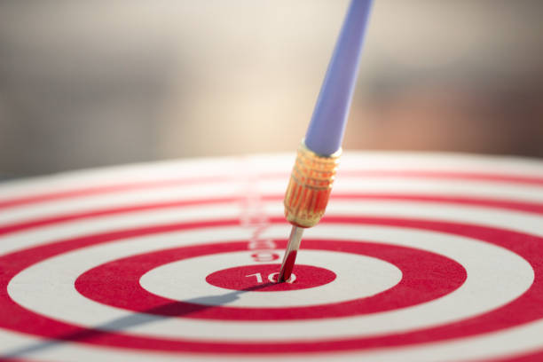 seta dos dardos que bate no centro do alvo do dartboard. objetivo do negócio do conceito ao sucesso do mercado. - bulls eye fotos - fotografias e filmes do acervo