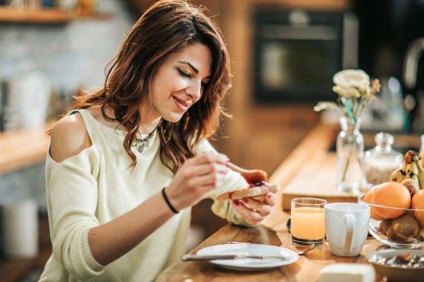 istock Young smiling woman preparing breakfast in the kitchen. 1143887666