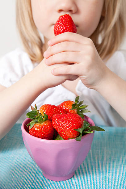 istock LIttle girl eating strawberries 114388915