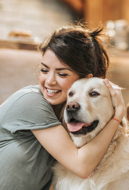 istock Happy affectionate woman embracing her retriever at home. 1143889428
