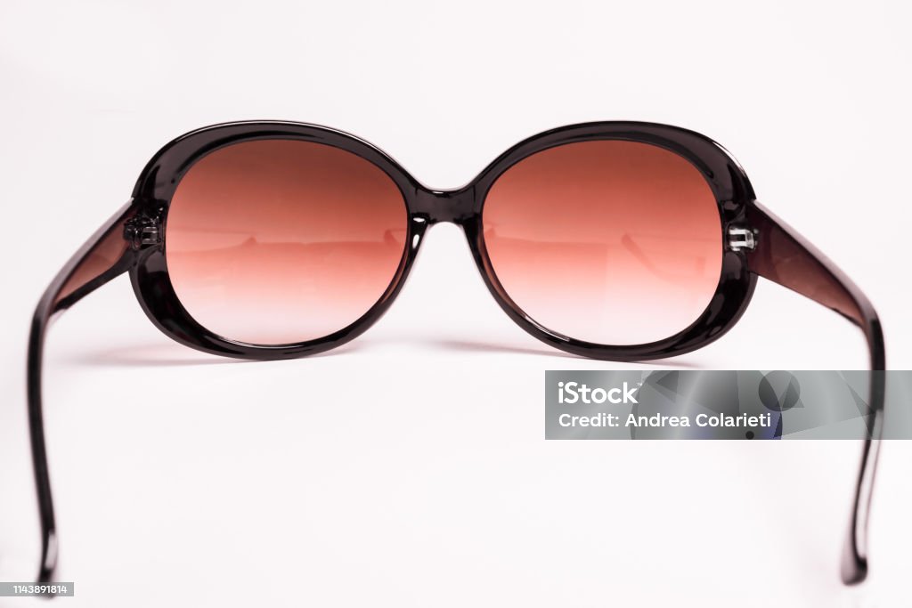 A pair of elegant and classic women's sunglasses with thick and vintage frames on a uniform white background Beauty Stock Photo