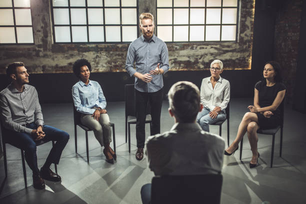 istock Young businessman talking to a coach during group therapy. 1143893071