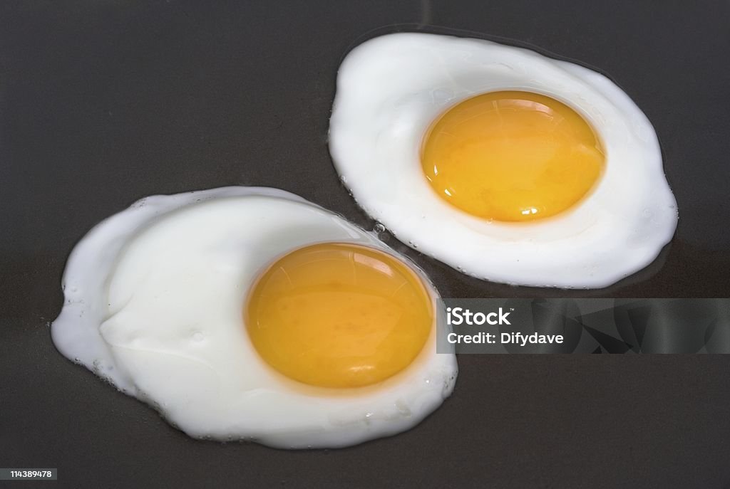 Dos huevos fritos ser preparado - Foto de stock de Alimento libre de derechos