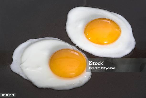 Dos Huevos Fritos Ser Preparado Foto de stock y más banco de imágenes de Alimento - Alimento, Alimentos cocinados, Amarillo - Color