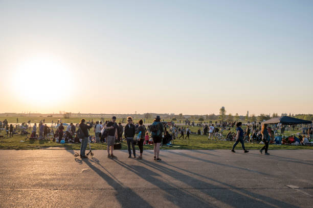 Berlin, Germany - April 19 2019:  Crowded park, People relax in springtime sun and do barbecue.